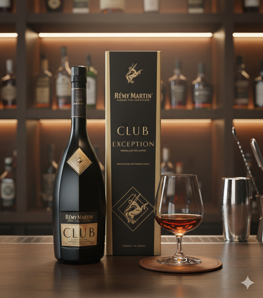 Rémy Martin Club Exception Cognac mit Geschenkbox und gefülltem Glas auf Bartresen, im stilvollen Barambiente mit Flaschen im Hintergrund