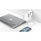 Universaladapter lädt gleichzeitig ein MacBook und ein Smartphone über USB-Anschlüsse an der Wandsteckdose